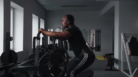 Black man doing leg workout in gym.Athlete training in gym machine doing squats Stock Footage 225712916