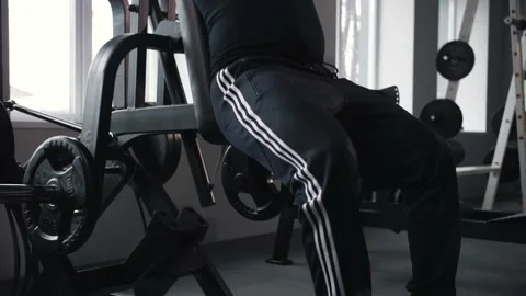 Black man doing leg workout in gym.Athlete training in gym machine doing squats Stock Footage 225713315