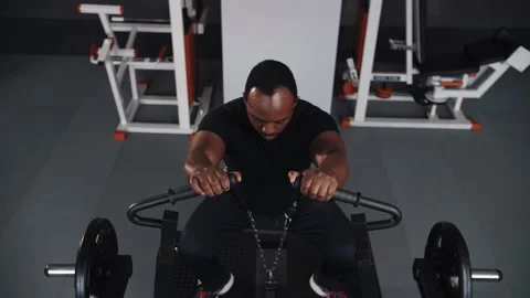 Black man doing leg workout in gym.Athlete training in gym machine doing squats Stock Footage 225714470