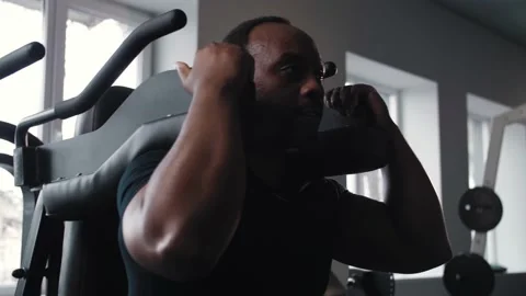 Black man doing leg workout in gym.Athlete training in gym machine doing squats Stock Footage 225717121
