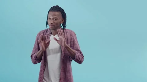 Black man with dreadlocks negative gestures with hands, standing on the blue Stock Footage 159742858