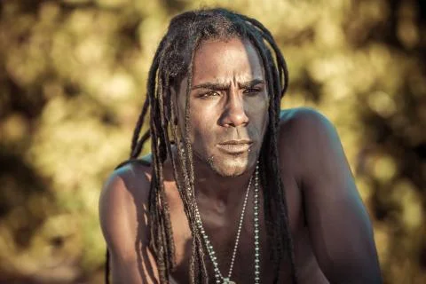 Black man with dreadlocks squints Foto stock