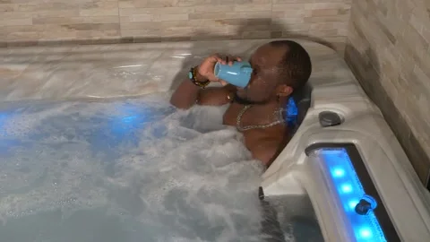 Black man drinks a coffee in a spa with his white girlfriend Stock Footage 225038351
