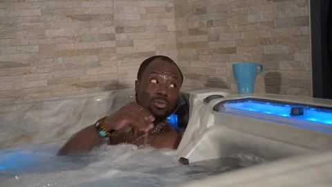 Black man drinks a tea in a spa Stock Footage 225038321
