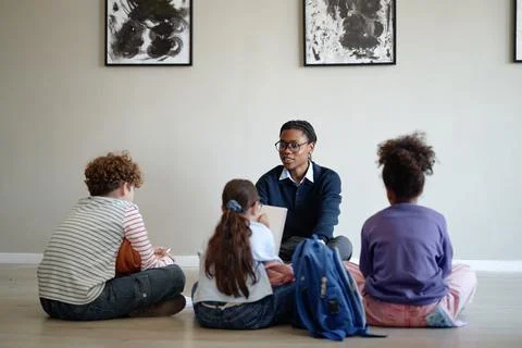 Black Man Educator Teaching Diverse Children in Art Gallery Stock Photos