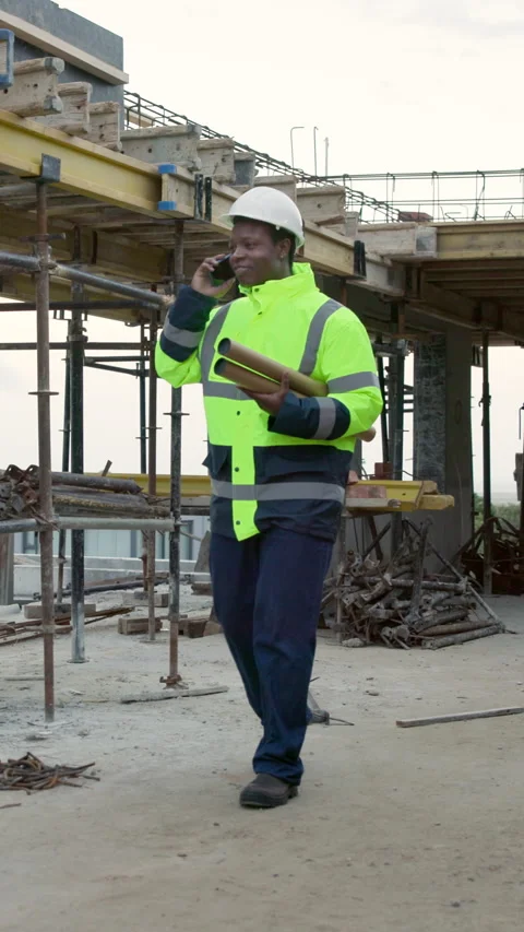 Black man, engineer and blueprint at site with phone call, inspection and Stock Footage 338010689