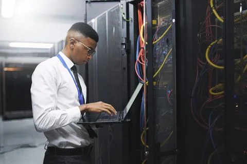 Black man, engineer and server room with laptop for network repair, hardware or Stock-Fotos