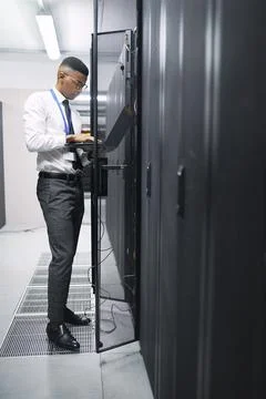 Black man, engineer and server room with laptop at data center for hardware Stock-Fotos