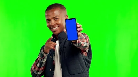 Black man, face and point with phone by green screen for mockup space, app promo Stock Footage 244221443