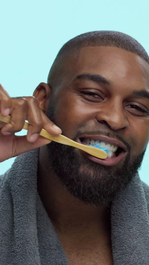 Black man, face and toothbrush for brushing teeth in studio, smile and bamboo on Stock Footage 308770539