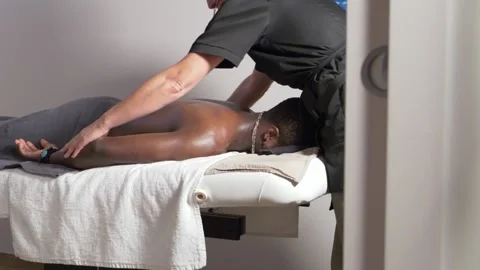 Black man getting his back massaged Stock Footage 225038376