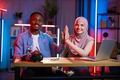 Black man giving high five to arab lady after cooperation working together at Fotos Stock