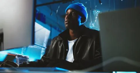 Black man, hacker and reading on pc at night for programming, cyber attack and Stock Photos