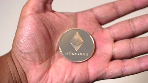 Black man hands closing around Ethereum coin Stock Footage 140988381