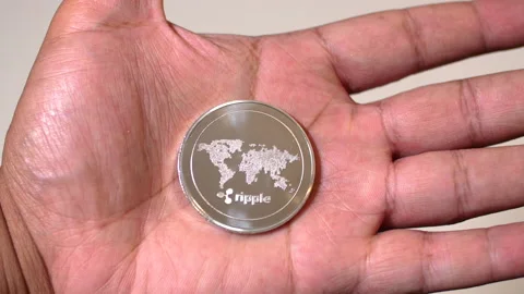 Black man hands closing around Ripple coin Stock Footage 140988529
