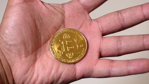 Black man hands closing around Bitcoin Stock Footage 140988544