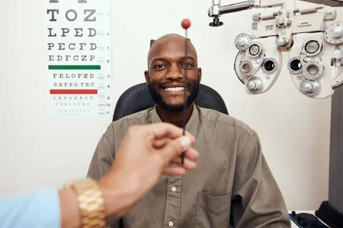 Black man having his eyes tested at an optometrist. Smiling African American Stock Photos