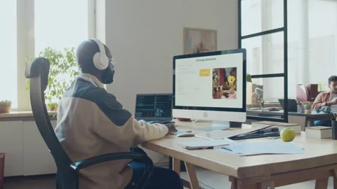 Black Man in Headphones Writing Code for AI Image Generation Software in Office Stock Footage 293119458