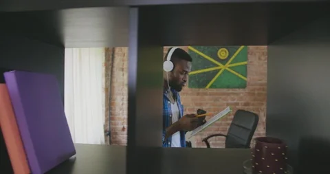 Black man holds documents, tries to make a decision and looks puzzled in modern Stock Footage 112553593