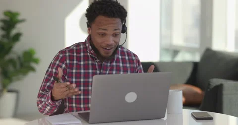 Black man at home using laptop computer remote work talking to co-worker Stock-Footage 169364955