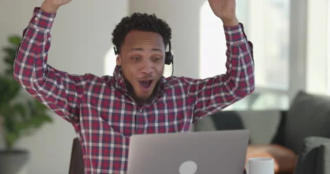 Black man at home using laptop computer remote work talking to co-worker Stock Footage 169374491