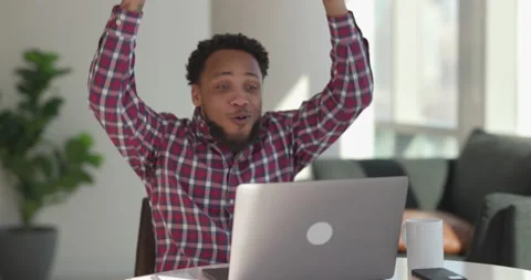 Black man at home using laptop computer remote work talking to co-worker Video stock 169374970
