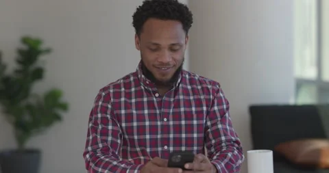Black man at home using smartphone texting 库存影片 169423421