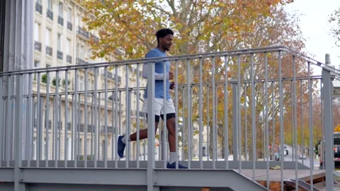 Black man jogging on a city bridge in paris Stock Footage 327456842