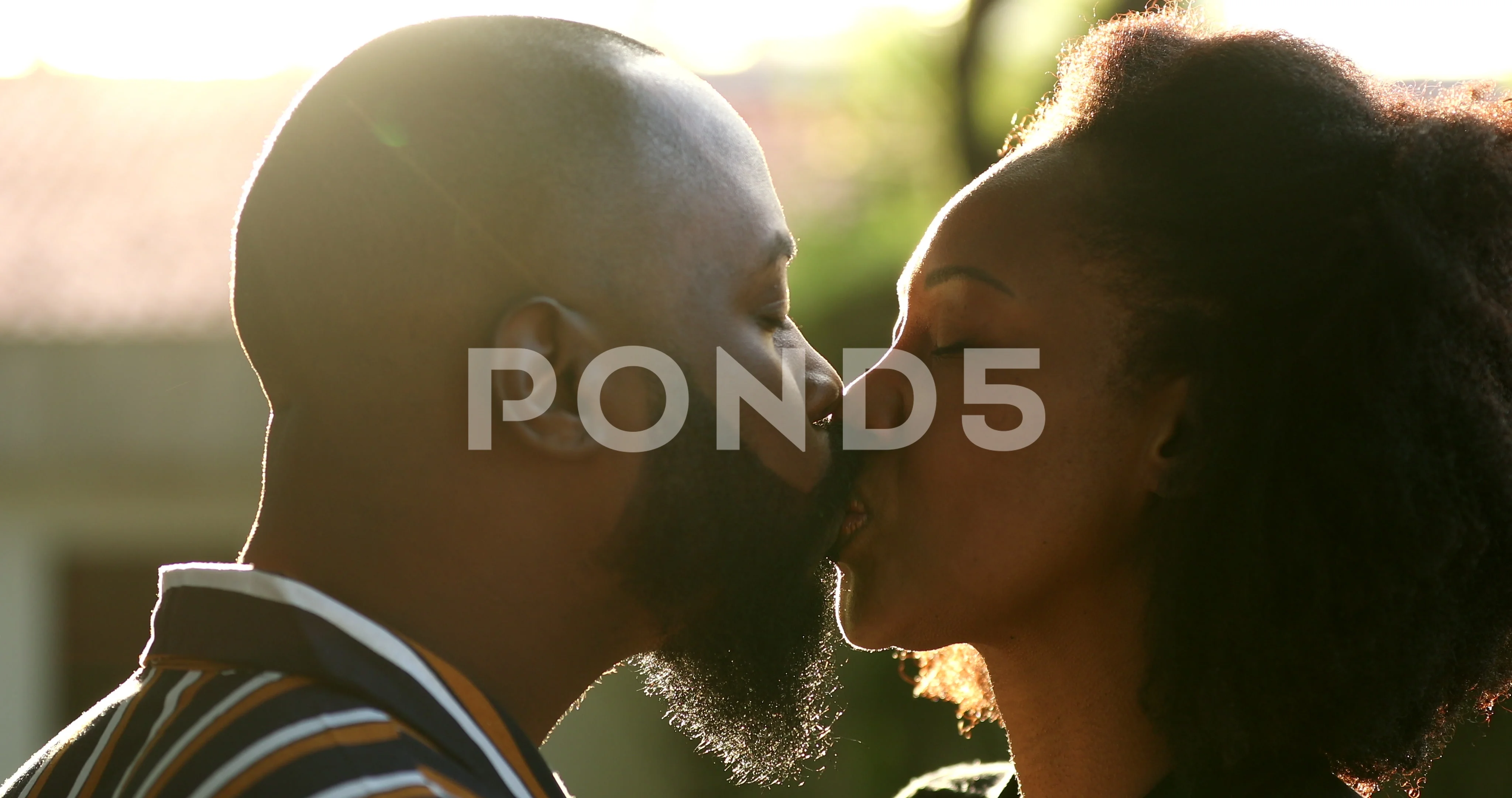 Black man kissing wife outside with lens.. pic picture