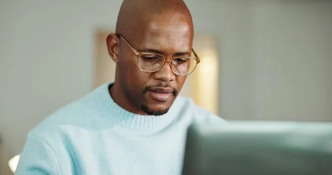Black man, laptop and thinking in home with remote work, review and report for Stock Footage 336792384