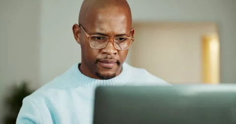 Black man, laptop and thinking in lounge with remote work, review and report for Stock Footage 336794410