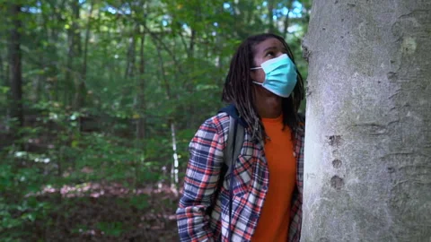 Black Man With Locks Wearing Face Mask Appreciates Tree in Nature Stock Footage 142015943