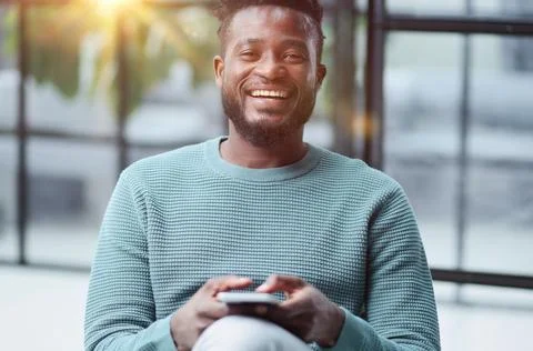 Black man looking at smartphone browsing internet, office technology and digital Stock Photos