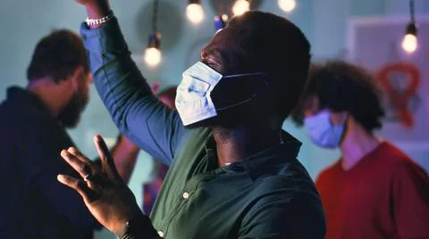 Black man in mask dancing during party Stock Photos