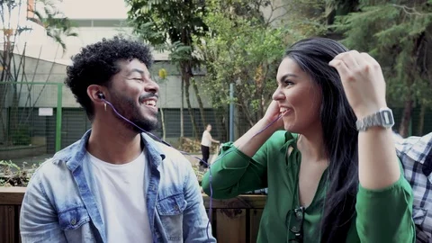 Black man offers the headset to her Brazilian friend. Stock Footage 117917524
