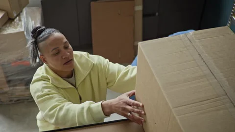 Black Man Passing Cardboard Box to Woman in Warehouse Stock Footage 337305960