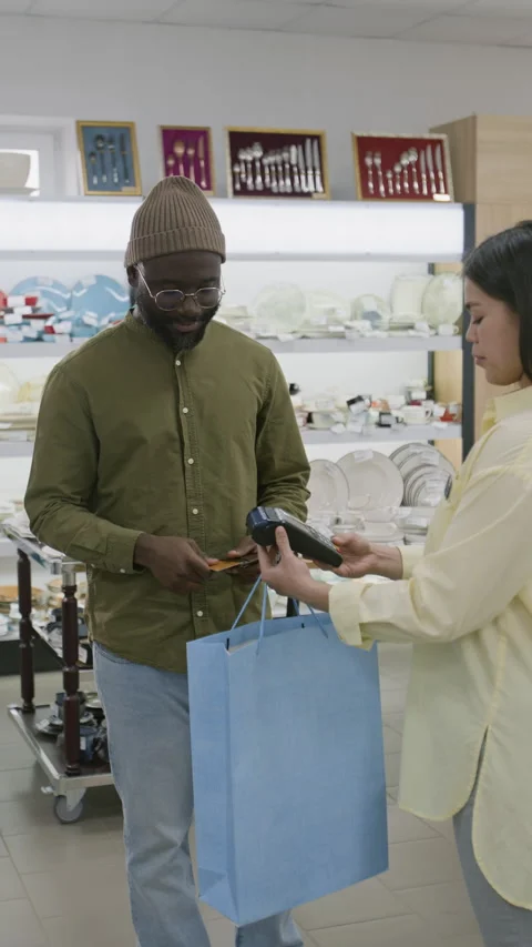 Black Man Paying with Card at Kitchenware Store and Thanking Saleswoman Stock Footage 321775249