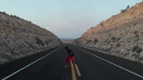 Black Man Performs Butterfly Twist on Highway Pavement, Aerial View Stock Footage 146552254