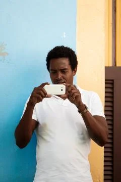 Black man photographing with his mobile phone, cuba Stock Photos