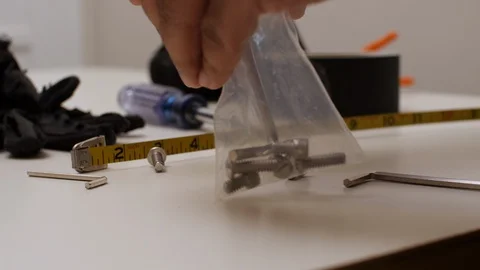 Black man picking up small screws Stock Footage 129349201