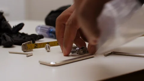 Black man picking up small screws Stock Footage 129352378