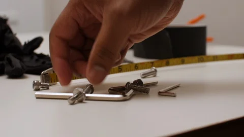 Black man picking up small screws Video stock 129398543