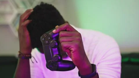Black man playing game using console controlling joystick. Entertainment during Stock Photos