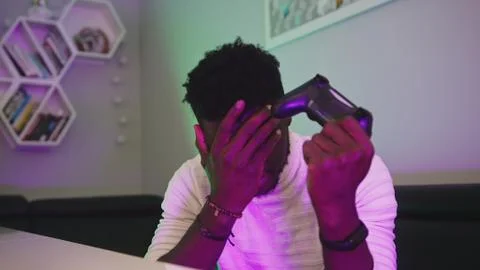 Black man playing game using console controlling joystick. Entertainment during Stock Photos