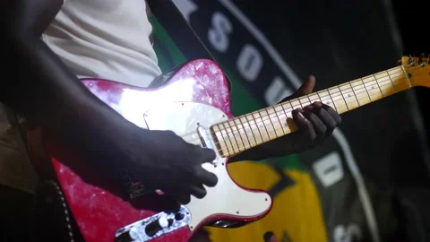 Black man playing on red and white electric guitar with light show Video stock 208939939