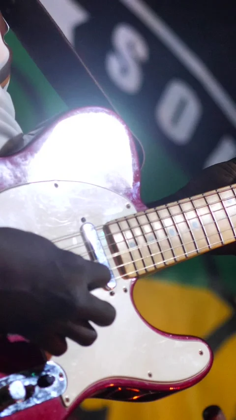 Black man playing on red and white electric guitar with light show Video stock 230686105