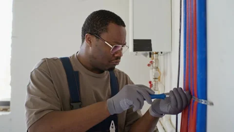 Black Man Plumber Installing Water Pipes during Home Renovation Stock Footage 340613622