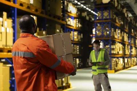 Black man preparing freight shipment by carrying cardboard boxes Stock Photos