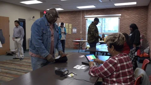 Black man presents ID to poll clerk Vidéo 106037092