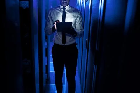 Black man, programmer and tablet in server room at night for research, codi.. Stock-Fotos